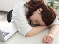 疲れがとれずデスクにうつ伏せしている女性